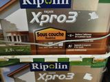 trois seaux de peinture empilés les uns sur les autres dans un magasin