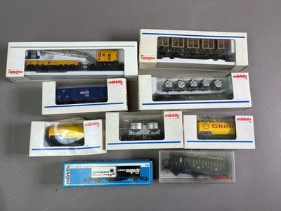 tout un tas de trains miniatures différents, rangés dans des boîtes sur la table