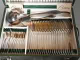 a green case with silverware in it on a table