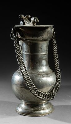 an old silver vase with a chain around it on a table
