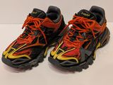 a pair of black and orange running shoes with orange laces
