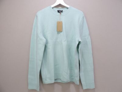 the light blue sweater is hanging on a hanger on the wall