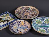 three decorative plates with designs on them on a black surface
