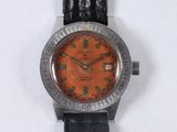 wrist watch with orange dial and black leather strap on white surface