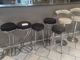 several stools are lined up against a counter in a restaurant