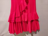 a pink skirt with ruffles hanging on a hanger