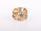 a close up of a gold ring with blue stones