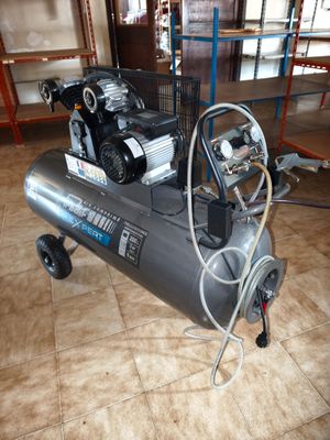 a small air compressor sitting on a cart in a room