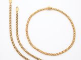 un bracelet à chaîne en or et un autre bracelet à chaîne en or sur fond blanc