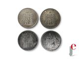 four different types of silver coins on a white surface