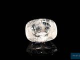 un diamant blanc sur une surface noire, avec un fond noir