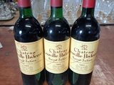 trois bouteilles de vin posées sur une table, à côté d'une étiquette de prix
