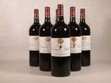 quatre bouteilles de vin rouge sont alignées sur une table