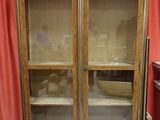 a cabinet that has a glass door on top of it