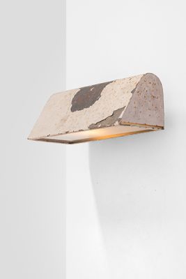 a close up of a light on a wall near a white wall
