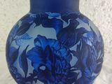 a blue vase with blue flowers on it sitting on a table