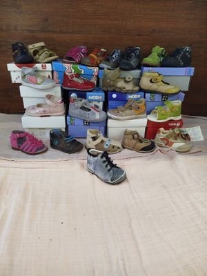 many pairs of shoes that are on a bed