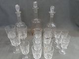 bottles and glasses are lined up in a circle on a table