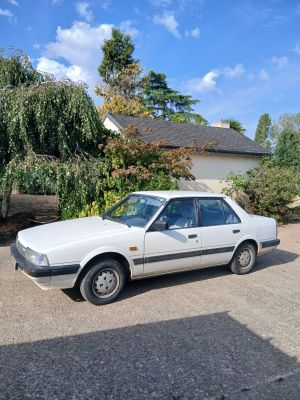 une voiture blanche garée devant une maison