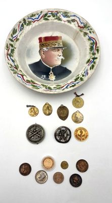 une assiette sur laquelle figure l'image d'un homme en uniforme militaire, entouré de pièces de monnaie