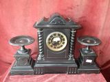 a black clock sitting on top of a red table