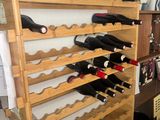 many bottles of wine on a wooden rack in the kitchen