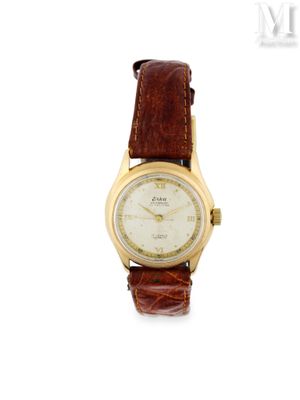 une photo d'une montre-bracelet plaquée or avec un bracelet en cuir marron