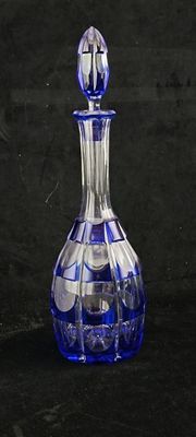 a blue glass decanter sitting on a black surface