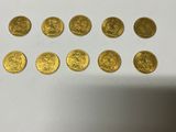 a bunch of gold coins sitting on top of a white table