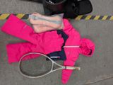 a tennis racket and a bag of clothing on the ground