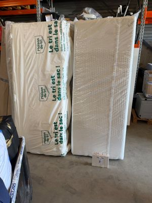 many mattresses stacked up in a warehouse with pallets