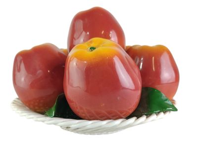 tomatoes in a basket with leaves on a white background