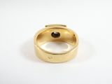 a close up of a gold ring with a black stone