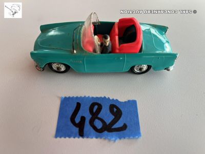 une petite voiture verte avec un siège rouge et une étiquette bleue