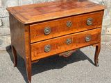 a small wooden chest of drawers on wheels on the ground