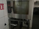 a small oven in the middle of a kitchen with a fire extinguisor