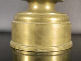a gold vase on a black table with a gray background