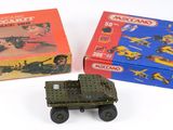 deux véhicules militaires miniatures et une boîte posés sur une surface blanche