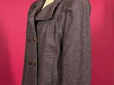 grey wool jacket on a mannequin stand against a red background