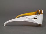 a white and yellow pair of glasses on a gray surface