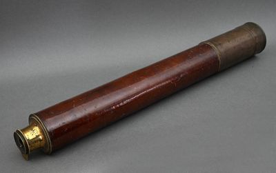 un vieux télescope en bois avec des ferrures en laiton sur fond gris
