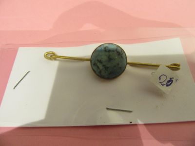 une photo d'une broche ornée d'une pierre verte
