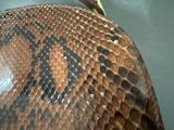 a close up of a snake skin purse on a table