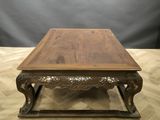 a wooden coffee table with ornate carvings on top of it
