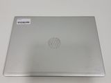 the back of a silver laptop sitting on top of a white table