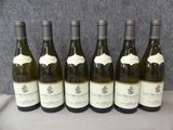 six bouteilles de vin sont alignées sur une table