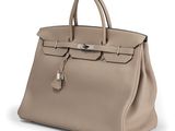 a beige leather handbag on a white background