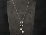 a black mannequin with a white pearl necklace on it