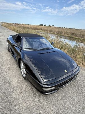 La voiture de sport noire est garée sur le bord de la route.