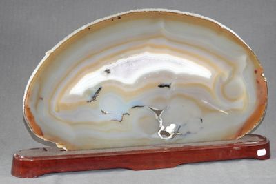 une agate blanche et brune posée sur un socle en bois